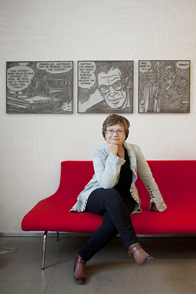 Gull-Britt Johansson sitter på en röd soffa
