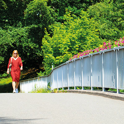 Kvinna går över en gångbro i betong