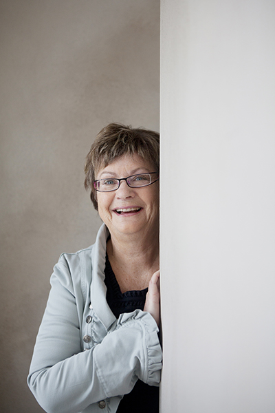 Gull-Britt Johansson sitter på en röd soffa