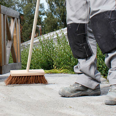 Fogsand sopas ner mellan trädgårdsplattor