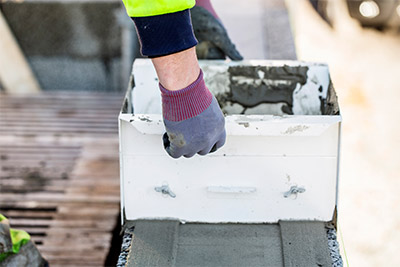 Murbruk appliceras på murblock med hjälp av en murlåda